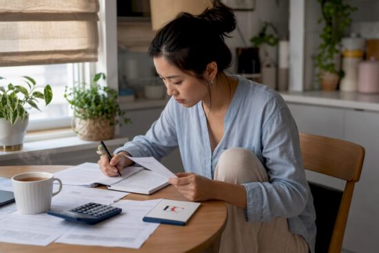 Woman organizing monthly budget at home