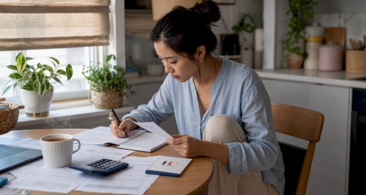 Woman organizing monthly budget at home