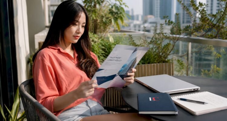 Young woman reading investment policy document at desk