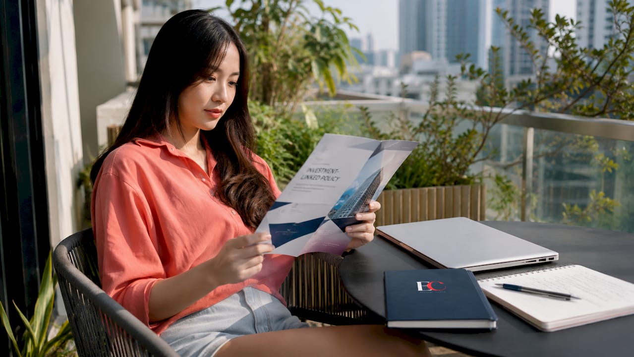 Singapore investment-linked policy explained for young adults 1 Young woman reading investment policy document at desk