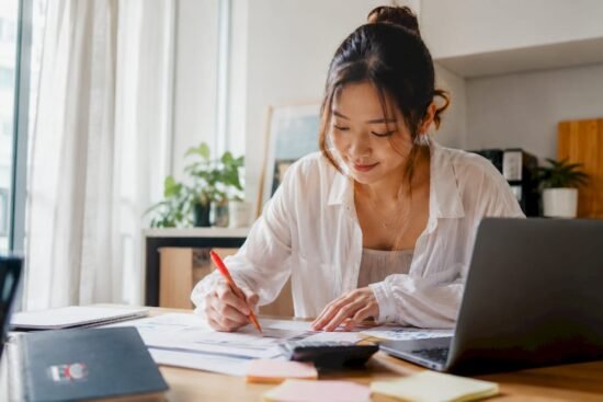 Young Singaporean woman budgeting at home desk