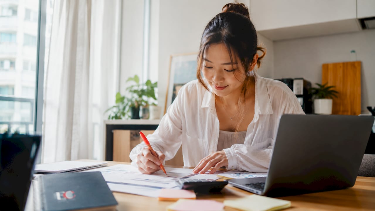 What is financial literacy: a guide for Singaporeans 1 Young Singaporean woman budgeting at home desk