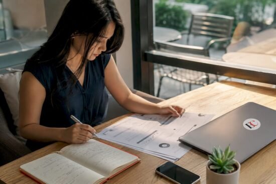 Young woman reviewing investment documents in home