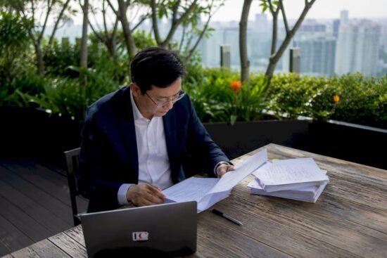 Compliance officer reviewing MAS regulations at desk