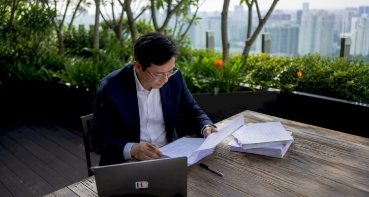 Compliance officer reviewing MAS regulations at desk