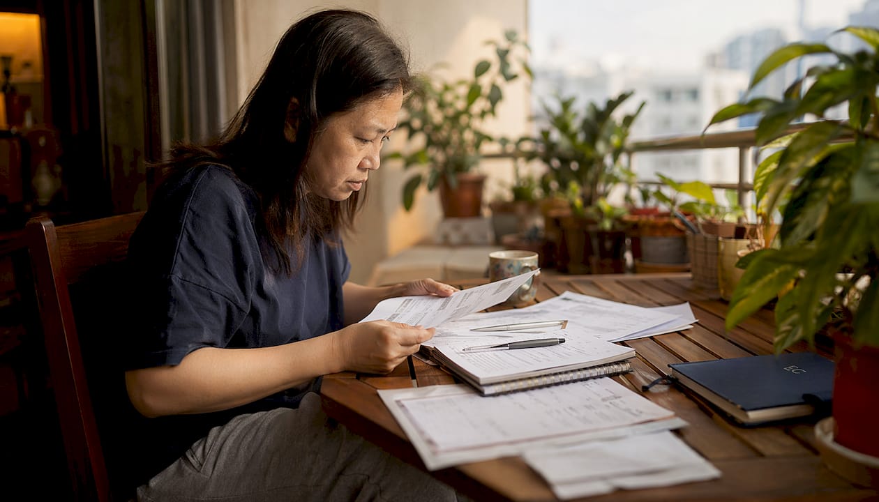 How to reduce household expenses in Singapore: 2026 guide 1 Woman budgeting household expenses at home
