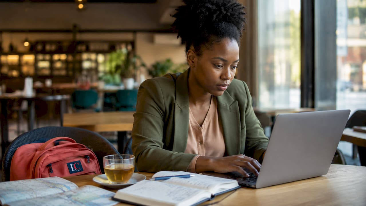 Is it cheaper to buy one way or round trip? 1 Traveler booking flights on laptop at airport lounge
